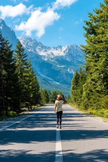 A young girl walking on the road in the Valbona valley, Theth national park, Albanian Alps, Valbona