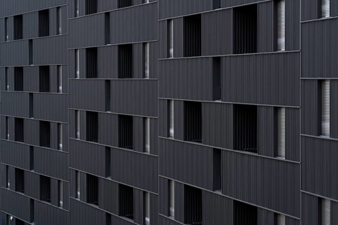 Modern building featuring a distinct, sustainable architectural style with vertically aligned,