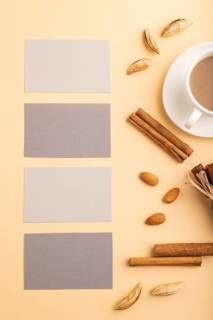 Composition of gray paper business cards, almonds, cinnamon and cup of coffee. mockup on orange