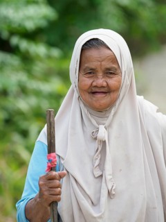 Old muslim woman, laughing with stick, Sulawesi, Indonesia