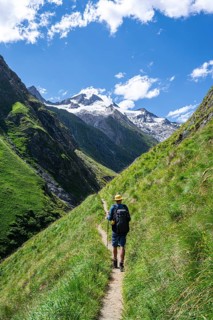 Mountaineers on a hiking trail in Umbaltal, glaciated mountain peaks in the background, Venediger