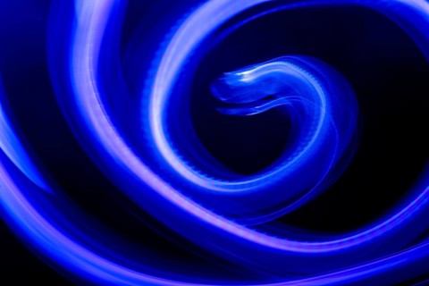 A mesmerizing abstract composition featuring swirling blue neon lights against a deep black
