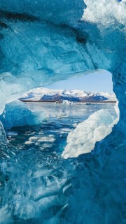 Stunning view from within a crystal-blue ice cave in Jokulsarlon, Iceland, framing the glacier