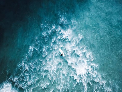 A stunning surf photo session in Portugal captures surfers navigating vibrant blue waves. The scene