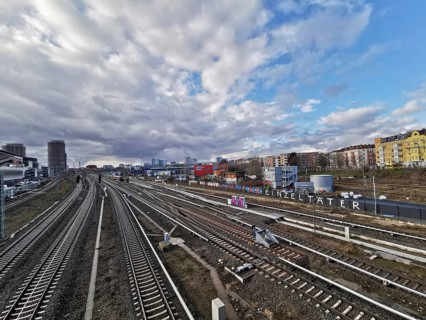 Panorma of urban rail infrastructure under a cloudy sky in summer with city in the background,