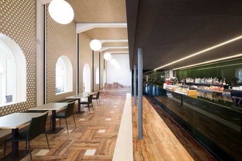 This spacious bar features modern architecture with sleek furniture, elegant lighting, and a