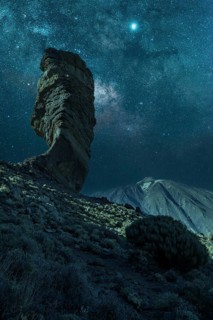 Milky way on the Roque Cinchado next to Teide in the natural park of Tenerife, Canary Islands.