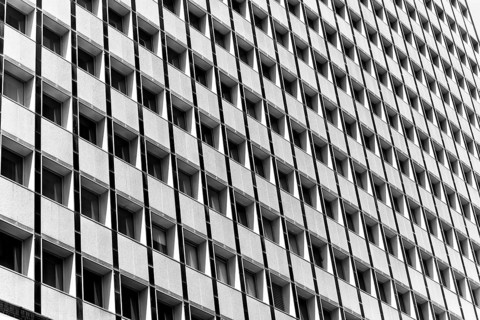 Black and white image of a building facade with repetitive square windows in Sidney, Australia.