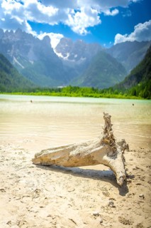 Tourists enjoy a summer swim in the turquoise waters of lago di landro with the dolomites and a sun