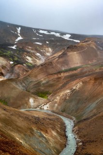 Steaming streams between colourful rhyolite mountains in the Hveradalir geothermal area,