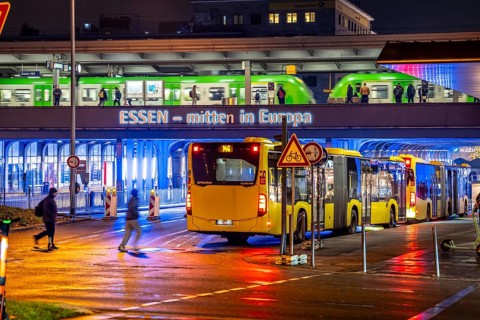 The main train station in Essen, blue illuminated underpass, bus station, am Europaplatz, train on
