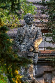 Statue of Vladimir Ilyich Lenin in front of the ruins of the Officers' House, officers' mess at the