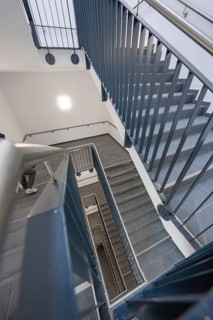View from above of a modern staircase with metal railing that connects several floors, new Calw
