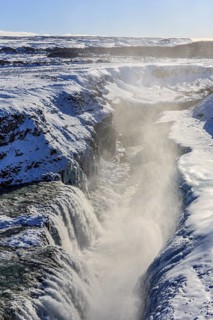 Large waterfall in a gorge in the snow, winter, sunny, backlight, spray, Gullfoss, Golden Circle,