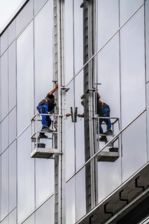 Window cleaner, facade cleaning, window cleaning, on a glass facade in Düsseldorf, ladder cage from