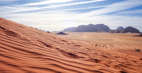 Captivating view over the red sand dunes in Wadi Rum Desert, Jordan, under a clear sky, with