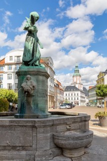 Pigeon girl on the Schlegel fountain in front of the town hall, in the background the Nicolai
