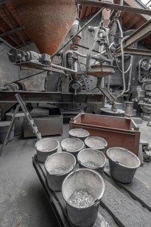 Bucket with zinc flakes in the production room with the metal powder grinding mill for the