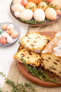 Homemade easter pie with raisins and eggs on plate on a gray concrete background and linen textile.