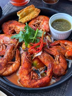 A flavorful dish of seasoned fried shrimp served with a spicy dipping sauce in a Thai cafe setting