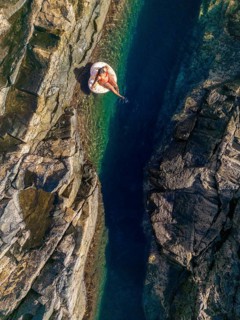 Top view of an unrecognizable woman floating on an inflatable in the clear, waters of a natural