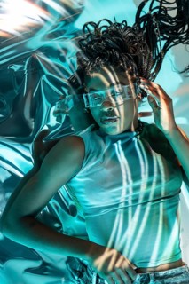 A futuristic young African woman wearing high-tech glasses, immersed in a vibrant and digital