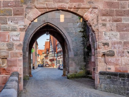 Alley with cobblestones leads through the town gate Oberes Tor, view through the gate to the