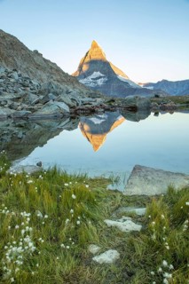 Serene landscape of the Matterhorn in the Swiss Alps, captured at dawn. The iconic peak reflects