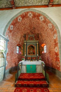 Interior and altar, walls with colourful frescoes in the Romanesque fieldstone church in the