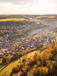 Aerial view of a village in autumnal colours with hills and trees at sunset, Sulz Calw, Black