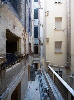 A detailed view of an urban renovation project, with exposed walls, construction materials, and