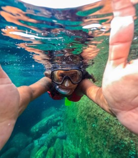 A snorkeler is captured half submerged in the clear waters of Tindaya Beach on Fuerteventura