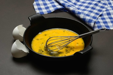 Cracked egg in a pan, hen's egg and eggshells