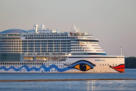 Cruise ship AIDA Prima leaving the harbour of Hamburg on the river Elbe in the evening light,