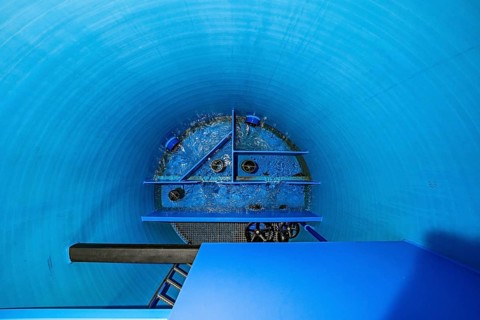 View into a blue cylinder with flowing water and structural elements, ENCW Netze Calw waterworks,