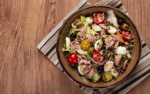 Salad with canned tuna, vegetable salad with quail eggs, lettuce, red onion, cherry tomatoes,