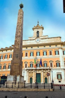 Italian parliament building Palazzo Montecitorio in the capital Rome, above the entrance flags of
