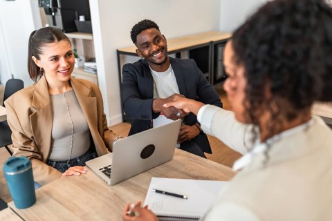 Smiling colleagues shaking hands after successful job interview, starting new business