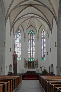 Chancel of the Gothic St. Clemens Church interior view, empty, pews, stained glass windows, Mayen,