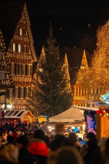 Illuminated Christmas market at night with half-timbered houses and people, Christmas market Calw,