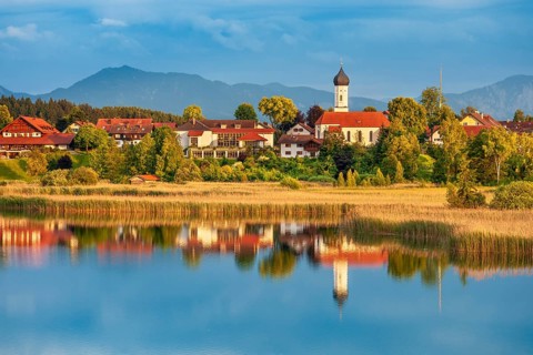 View over the Sengsee lake to Iffeldorf with St. Vitus church in autumn, Osterseen, Fünfseenland,