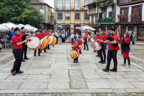 Traditional drum and pipe band perform on city streets on May Day 2025, Guimaraes, Braga district,