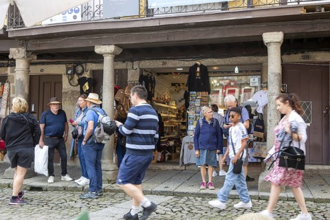 People in street outside tourist souvenir shop, city of Guimaraes, northern Portugal