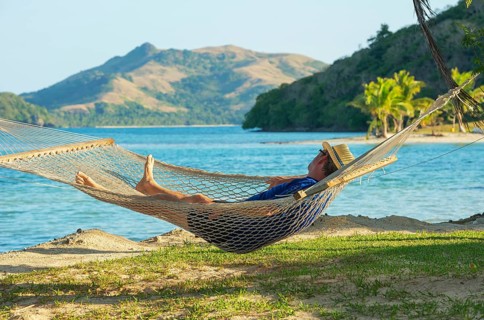 Man relaxing in hammock and enjoying sea view, Yasawa islands, Fiji