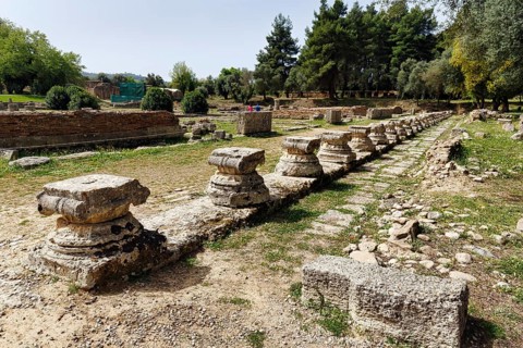 Restored ruins, column bases, columns, Leonidaion, ancient Olympia in spring, archaeological site,