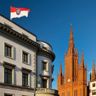 Hessian parliament with state flag in the former Nassau castle and market church, state capital