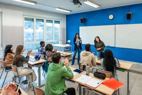 Multi ethnic university students clapping hands after a classmate presentation in a modern
