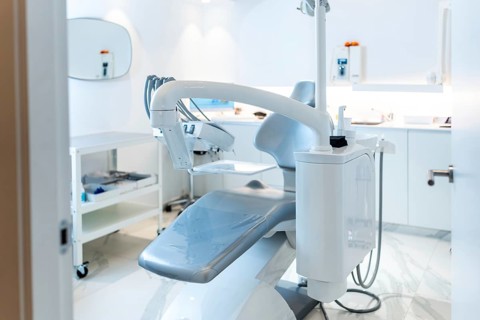 Empty dentist chair in a modern, clean and bright dental clinic, ready for the next patient