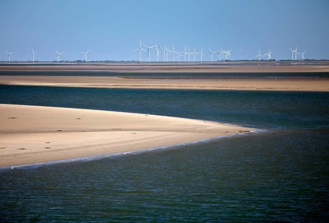 Schleswig-Holstein Wadden Sea National Park with sandbanks and wind turbines on the mainland, North