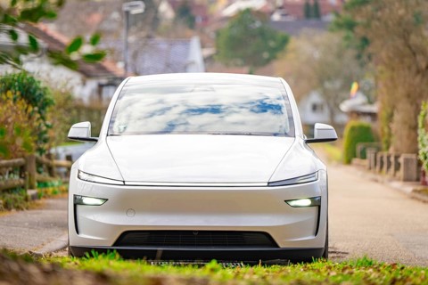 White electric car on rural road, surrounded by autumn landscape in quiet atmosphere, Tesla, New